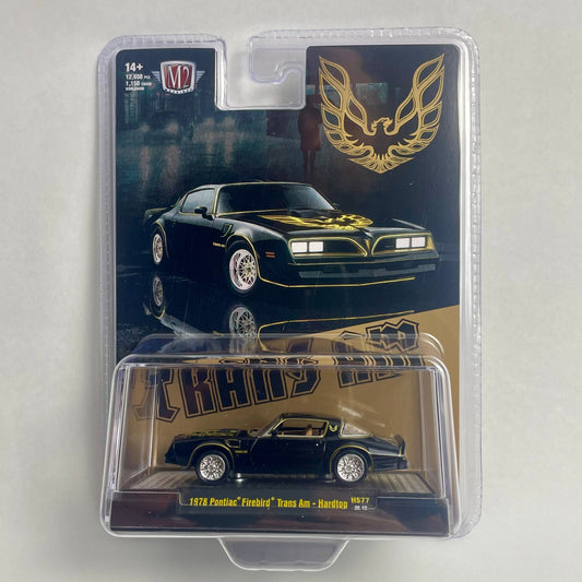 A packaged die-cast model car of a 1969 Pontiac Firebird 'Cosworth' Trans Am in black with gold accents, shown in its original blister pack against a light gray background.