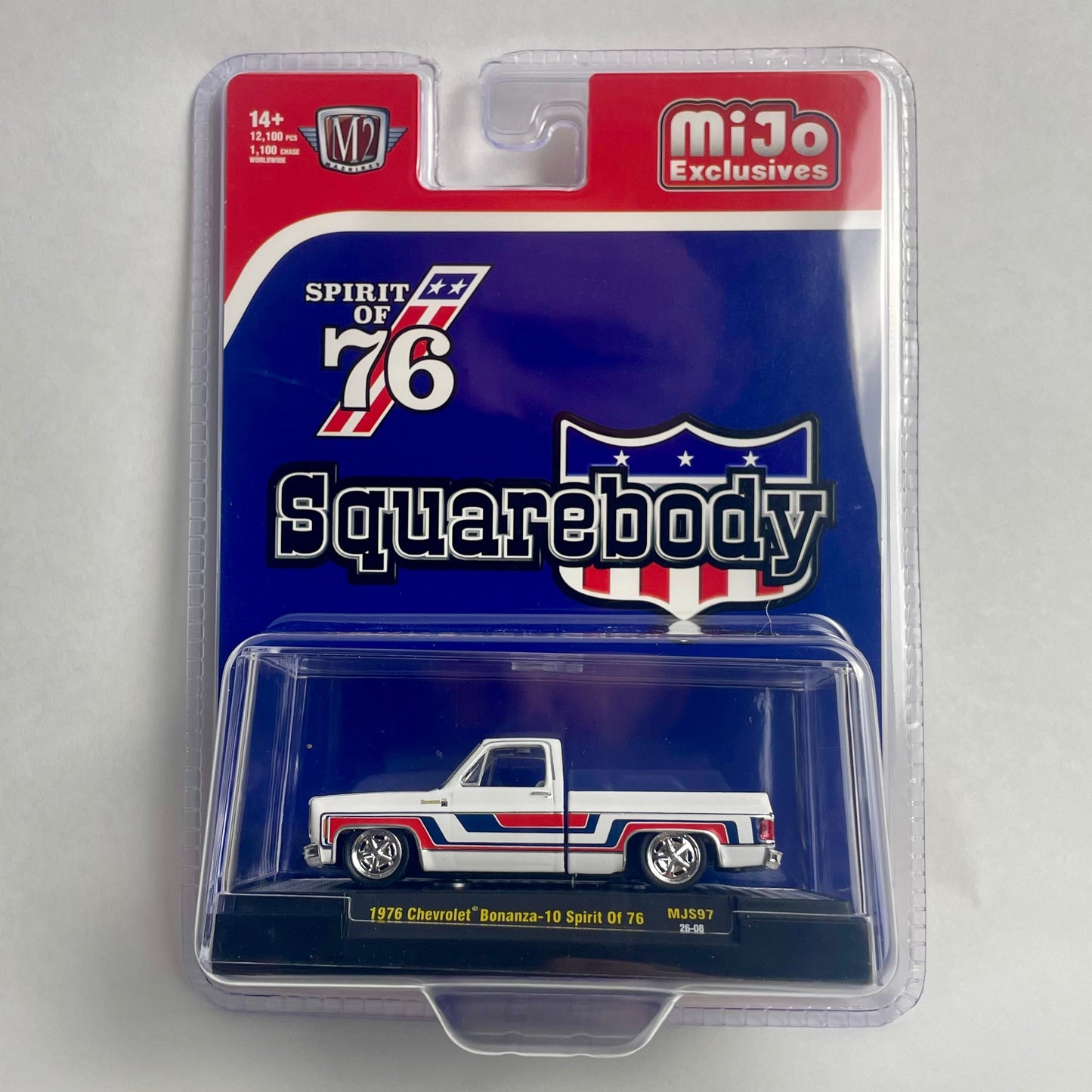 A packaged die-cast model car of a 1976 Chevrolet Nomad 1/4 scale vehicle, featuring a white body with red and blue stripes, in its original blister pack with a blue and red backing card.