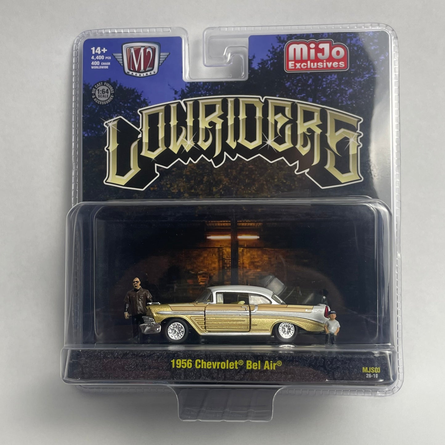 A packaged 1:64 scale die-cast model car of a 1959 Chevrolet Bel Air in gold and white, displayed inside a clear blister pack with a 'Lowriders' branded backing card.